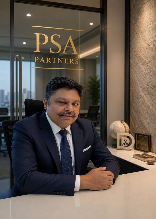 Professional man in navy suit at desk in PSA Partners office with city skyline view